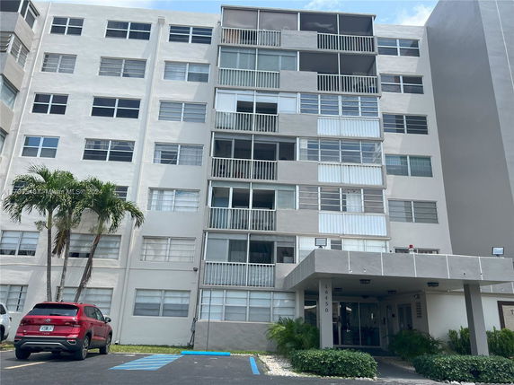 Front view of a multi-story apartment building with balconies.