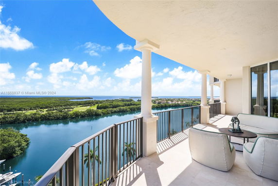 Wide angle view from a building balcony overlooking water and green landscape.