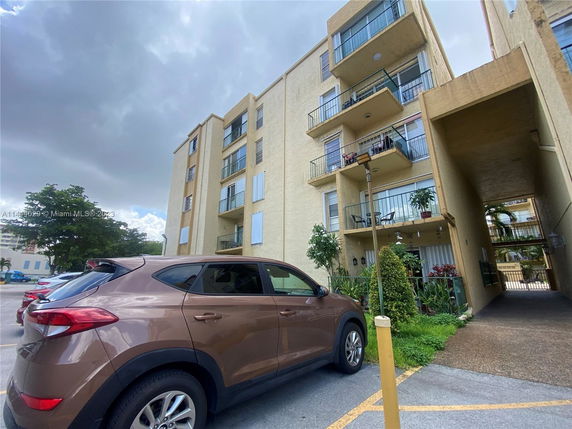 Front view of a multi-story apartment building with balconies.