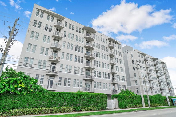Front view of a multi-story residential building with balconies.