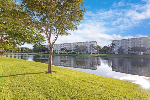 View of multi-story apartment buildings across a pond.