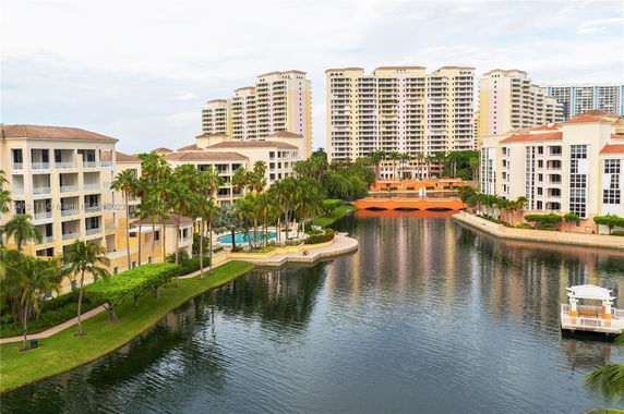 View of multiple residential buildings with balconies near a waterway.