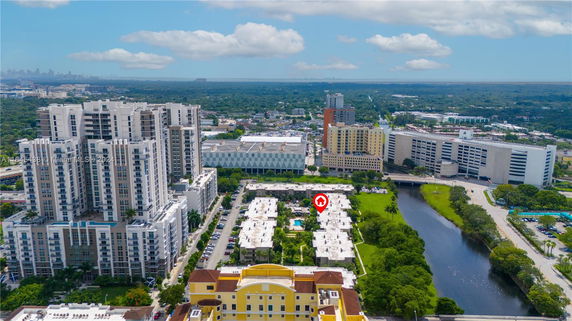 Aerial view of urban area with multiple high-rise buildings and a waterway.