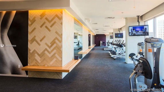 Interior view of a gym with exercise equipment and decorative walls.