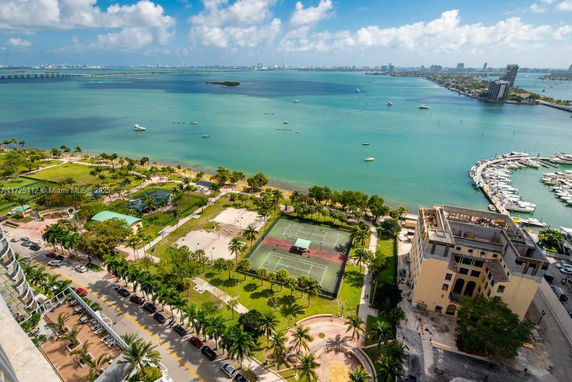 Panoramic view of a coastal area with tennis courts, waterfront, and marina.