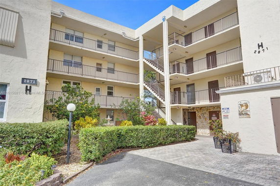Front view of a multi-story residential building with external staircases.
