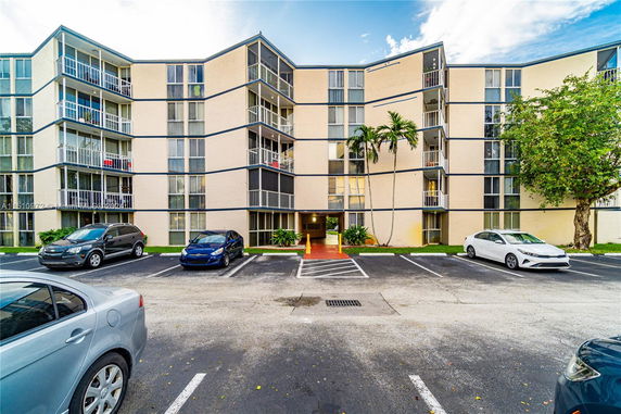 Front view of a multi-story apartment building with balconies.
