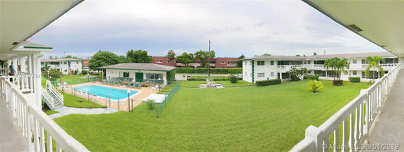 Panoramic view of an outdoor swimming pool area surrounded by residential buildings.