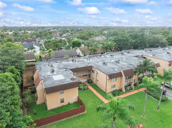 Aerial view of apartment buildings with flat rooftops and air conditioning units.