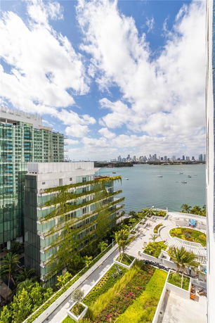 Panoramic view from a building overlooking water and a city skyline.