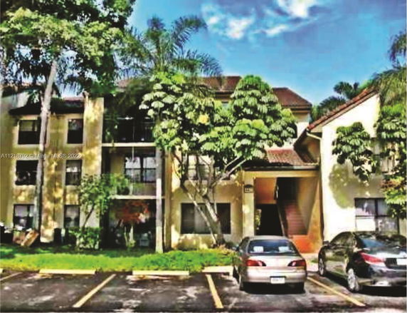 Front view of a multi-story residential building with a parking area.