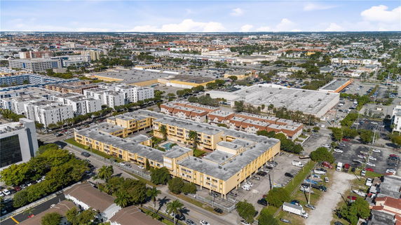Aerial view of a cityscape with various residential and commercial buildings.