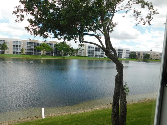 View of a multi-story apartment complex across a body of water.