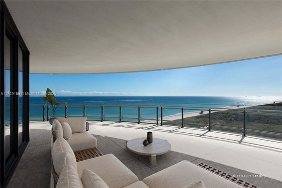Wide angle view from a balcony overlooking the ocean and beach.
