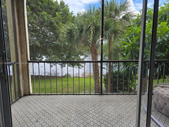 View from a balcony overlooking a water body and trees.