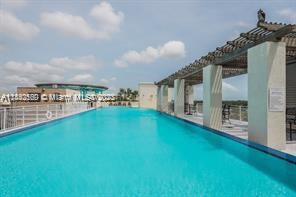 Outdoor swimming pool with a pergola structure and clear skies.