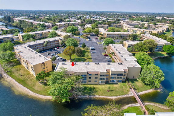 Aerial view of a residential complex with multiple buildings and parking areas.