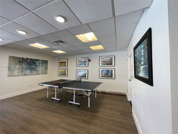 Room with a table tennis setup and framed artwork on the walls.