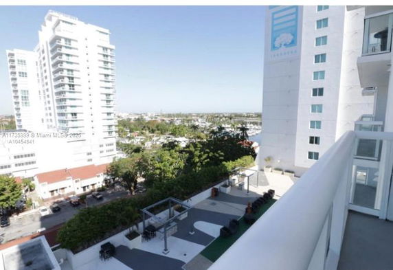 View from a building balcony overlooking nearby buildings and landscape.