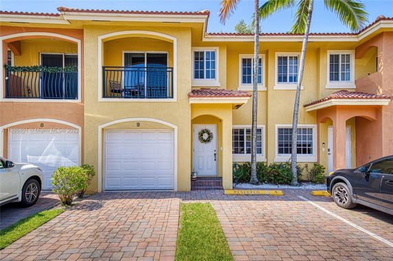 Front view of a two-story townhouse with a garage and a small balcony.