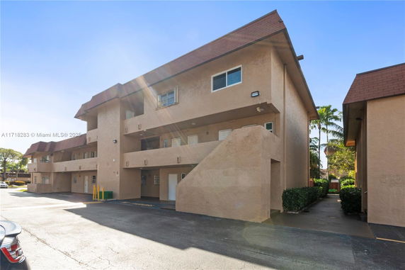Front view of a multi-story building with a beige exterior and a brown roof.
