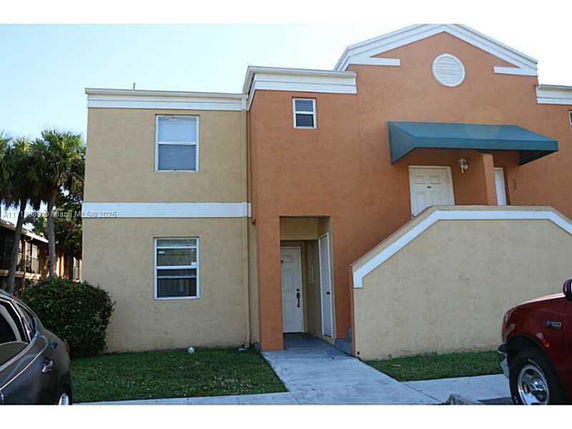 Front view of a two-story building with an exterior staircase.