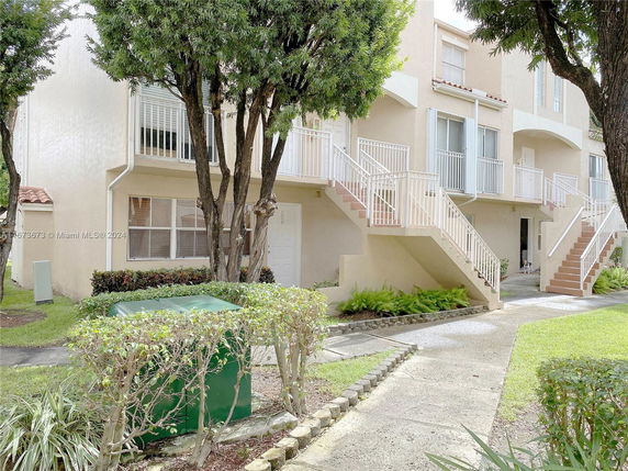 Front view of a multi-story residential building with multiple staircases and balconies.