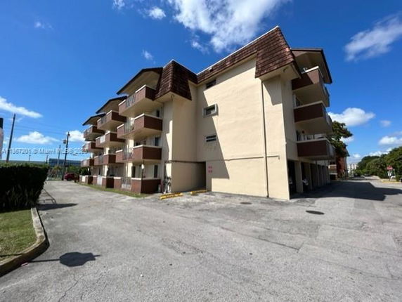 Front view of a multi-story apartment building with multiple balconies.