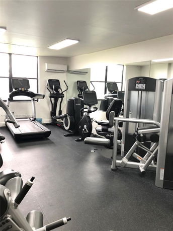 Indoor gym with exercise equipment including treadmills and stationary bikes.