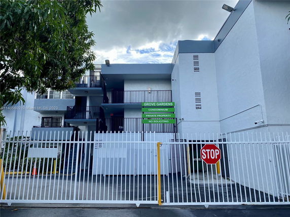 Front view of a multi-story condominium building with gated entrance.