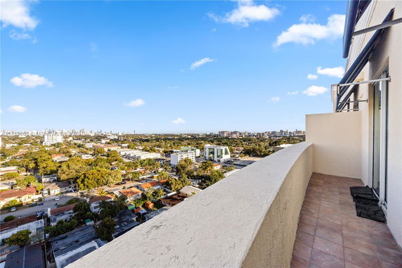 Panoramic view from a building balcony overlooking a city landscape.
