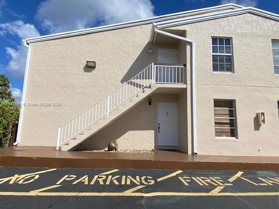Front elevation of a two-story building with an external staircase and a door marked '7'.