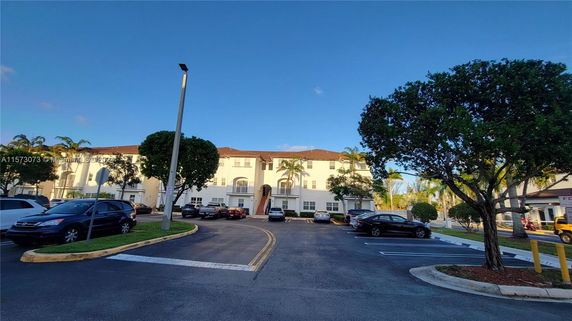Outdoor parking area in front of a multi-story residential building.