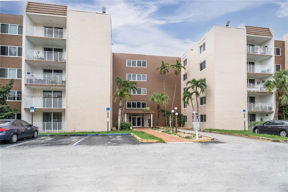 Front view of a multi-story apartment building with balconies.
