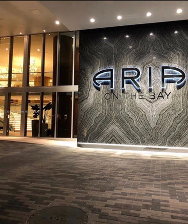 Front view of a building with illuminated signage and glass facade.