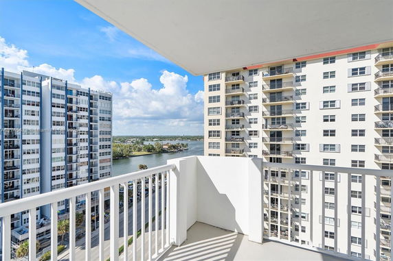 View from a balcony overlooking adjacent high-rise buildings and waterway.