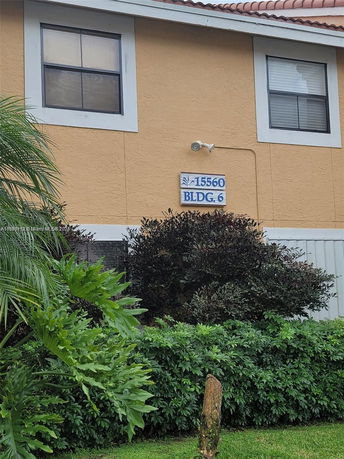 Front view of a two-story building with windows and a building number sign.