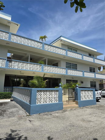 Front view of a multi-story building with decorative railings.