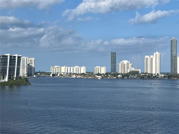Panoramic view of a cityscape with high-rise buildings along a waterfront.
