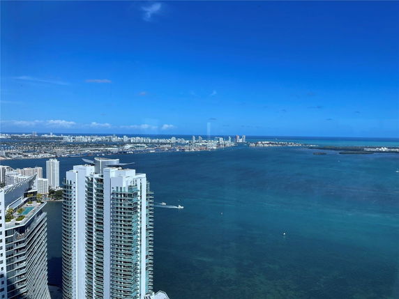 Panoramic view of high-rise buildings and the ocean observed from a high vantage point.