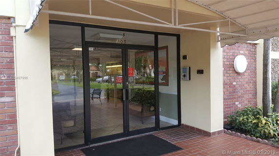 Entrance of a modern building with glass doors and brick exterior.