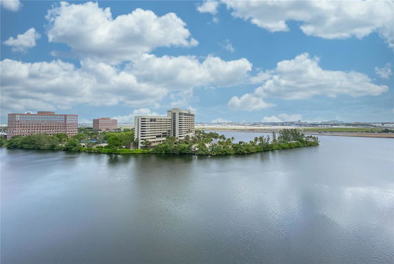 Panoramic view of a building complex surrounded by water with a clear sky.