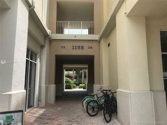 Entrance view of a building with a walkway and bicycles parked outside.