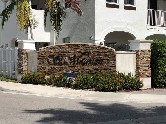 Front view of a building entrance with decorative stone wall and gate.