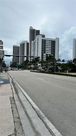 Front view of a group of tall modern buildings along a road.