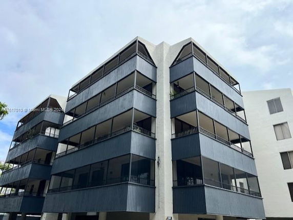 Front view of a multi-story building with balconies on each floor.