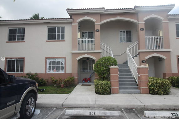 Front view of a two-story residential building with stair access to the upper level.