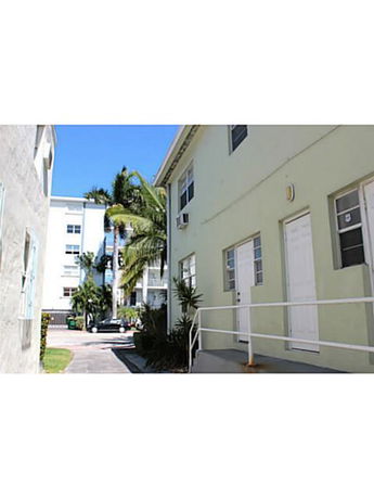 Side view of a multi-story building with doors and windows visible.