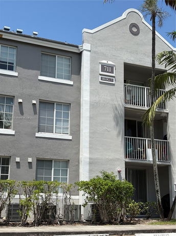 Front view of a multi-story apartment building with balconies.