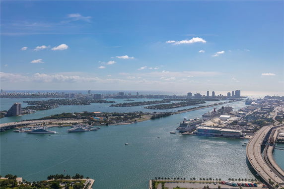 Panoramic view of a coastal city with water bodies and distant skyscrapers.